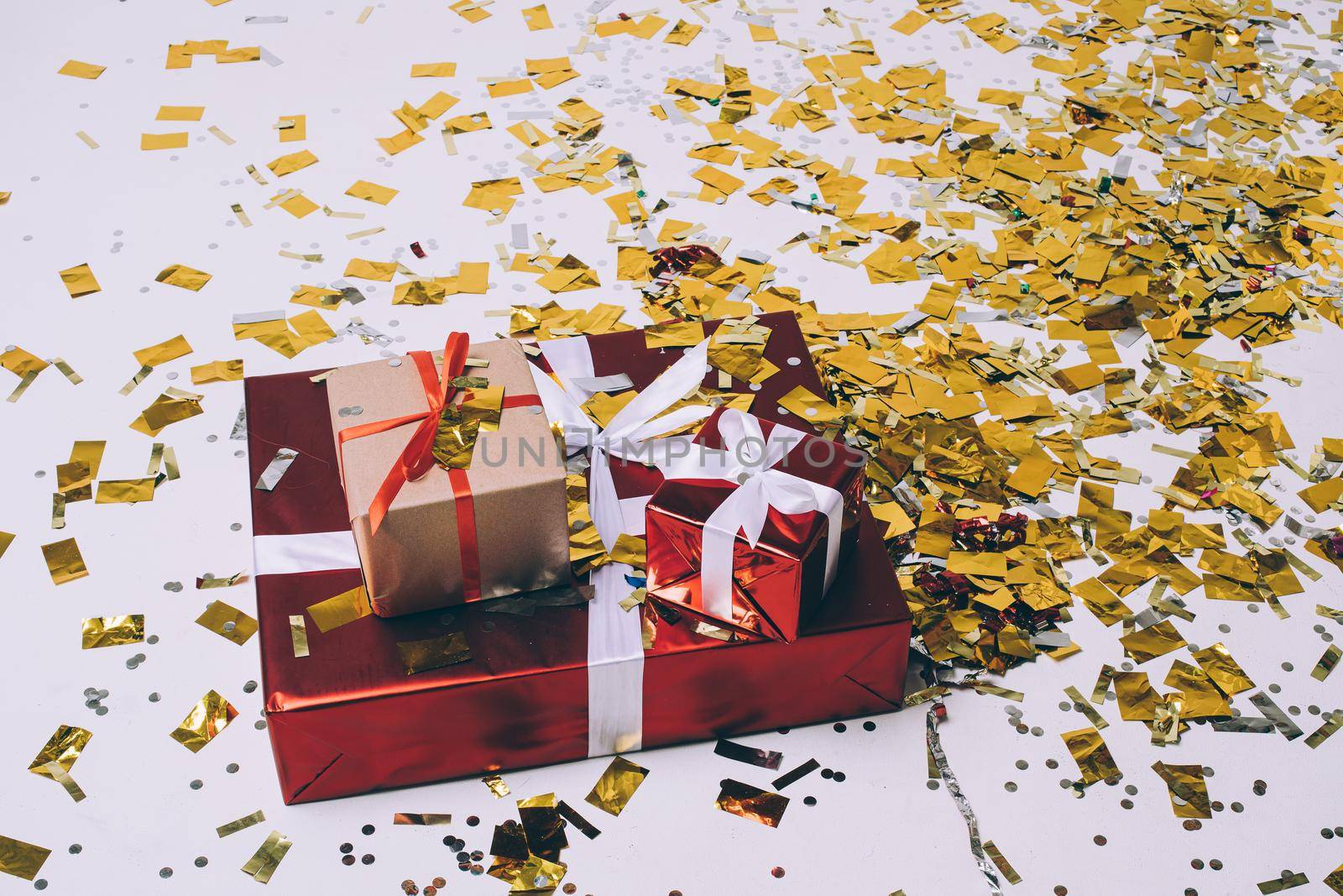 Christmas gifts, golden confetti, festive xmas presents wrapped in gift boxes with white and red ribbon, holiday design by StudioLucky