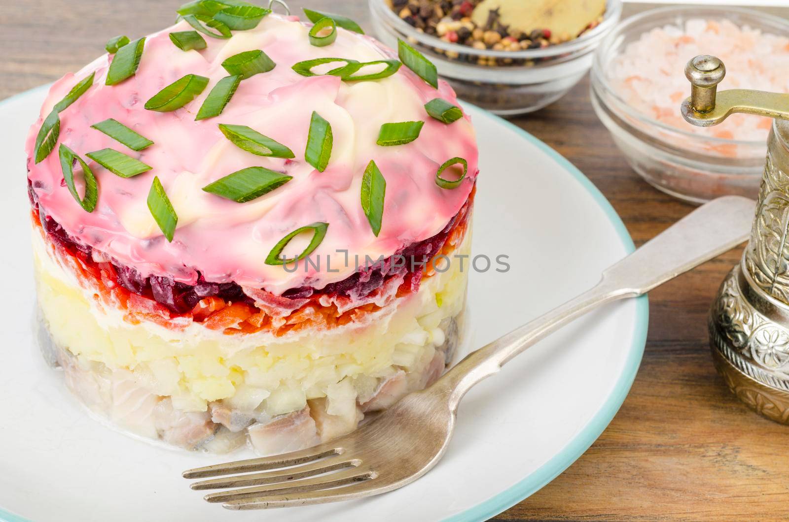 Plate with appetizer of beets, carrots, potatoes and salted fish on wooden table. Stuio Photo