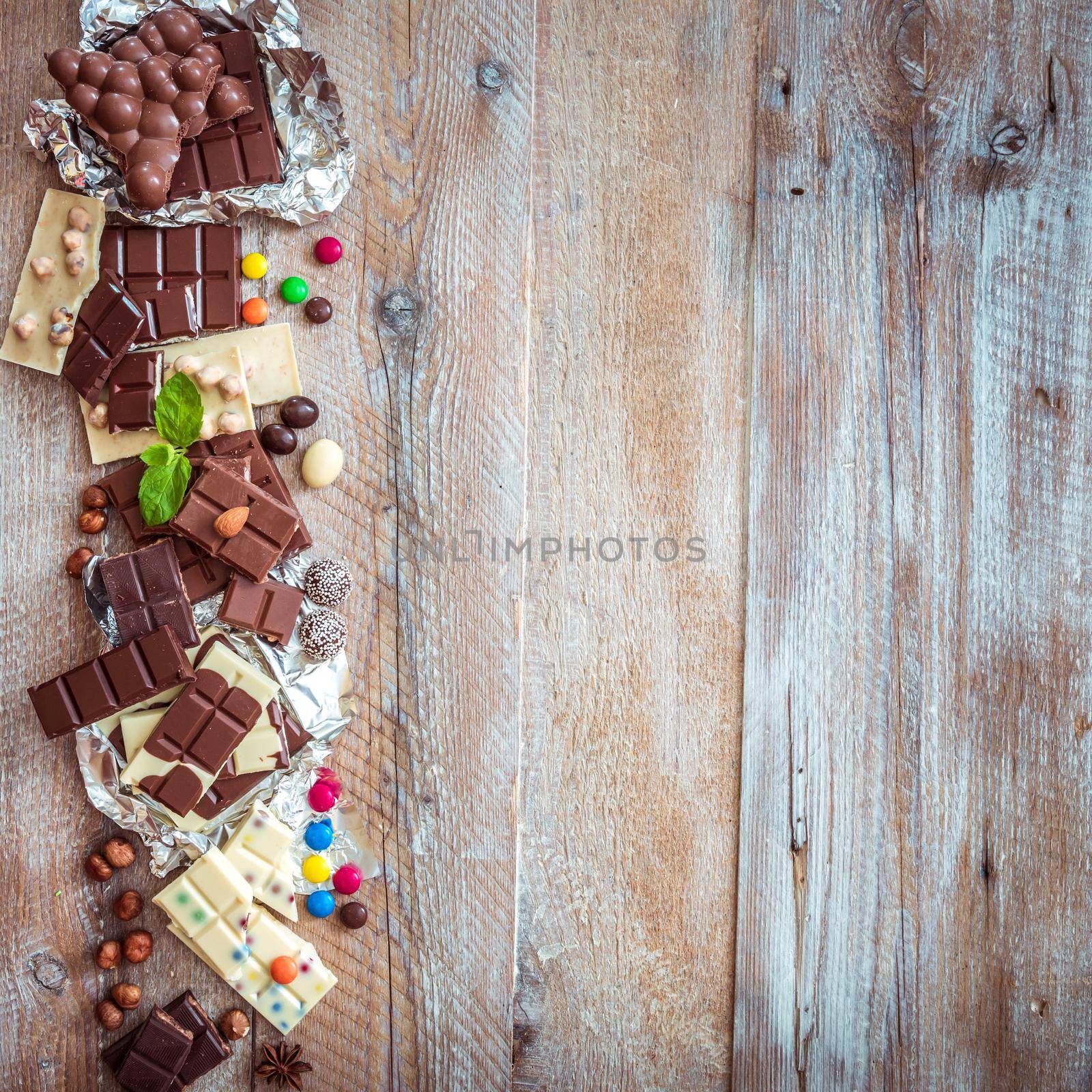 chocolate and candies on a wooden background with space for text