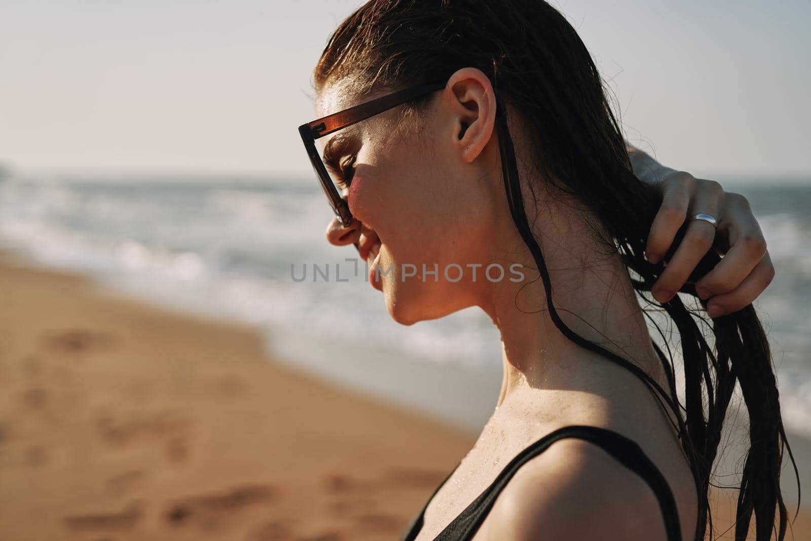 Cheerful woman black swimsuit ocean nature summer tan. High quality photo