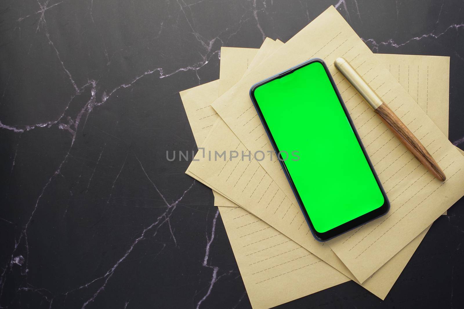 top view of smart phone and notepad on table .