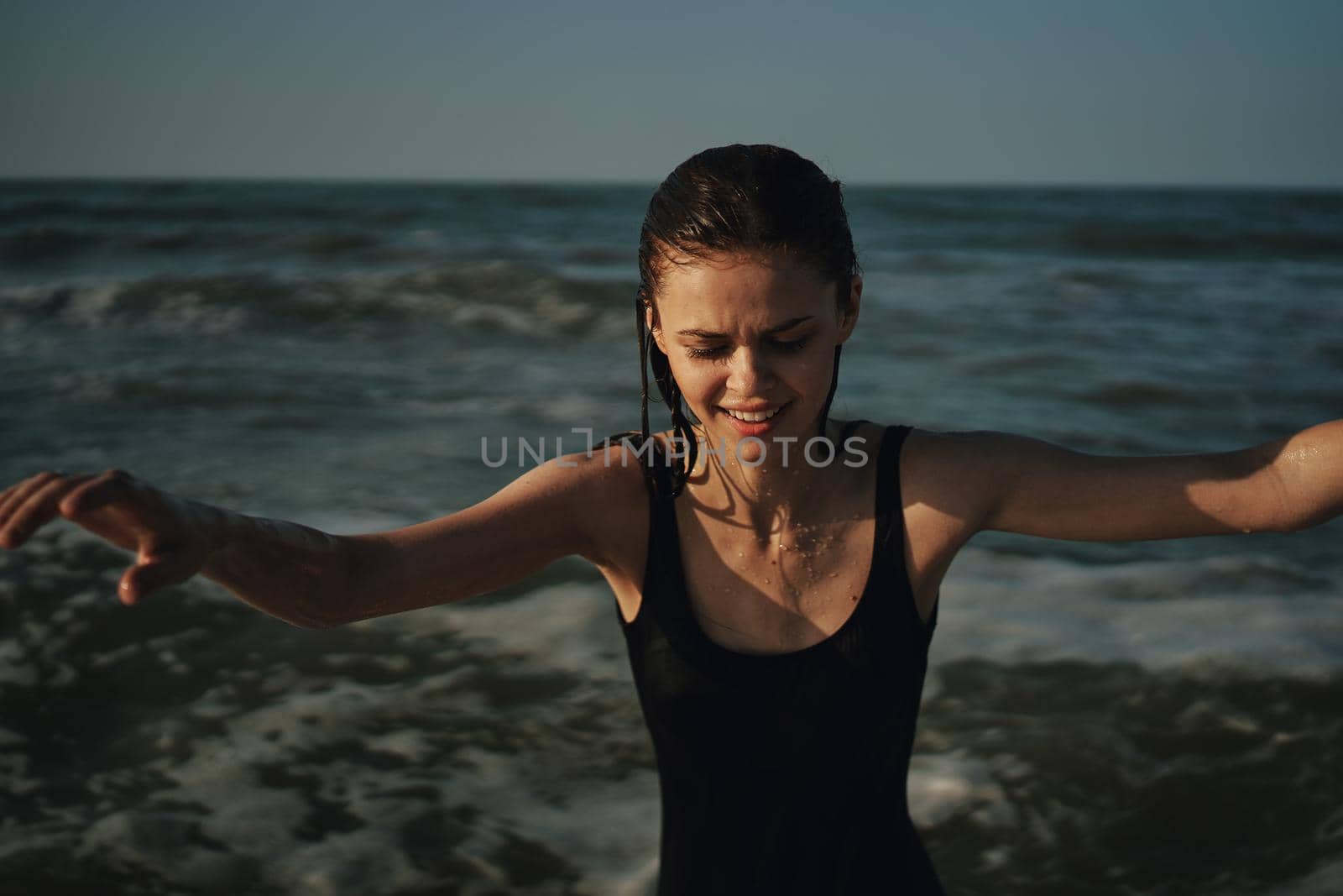 Cheerful woman black swimsuit ocean nature summer tan. High quality photo