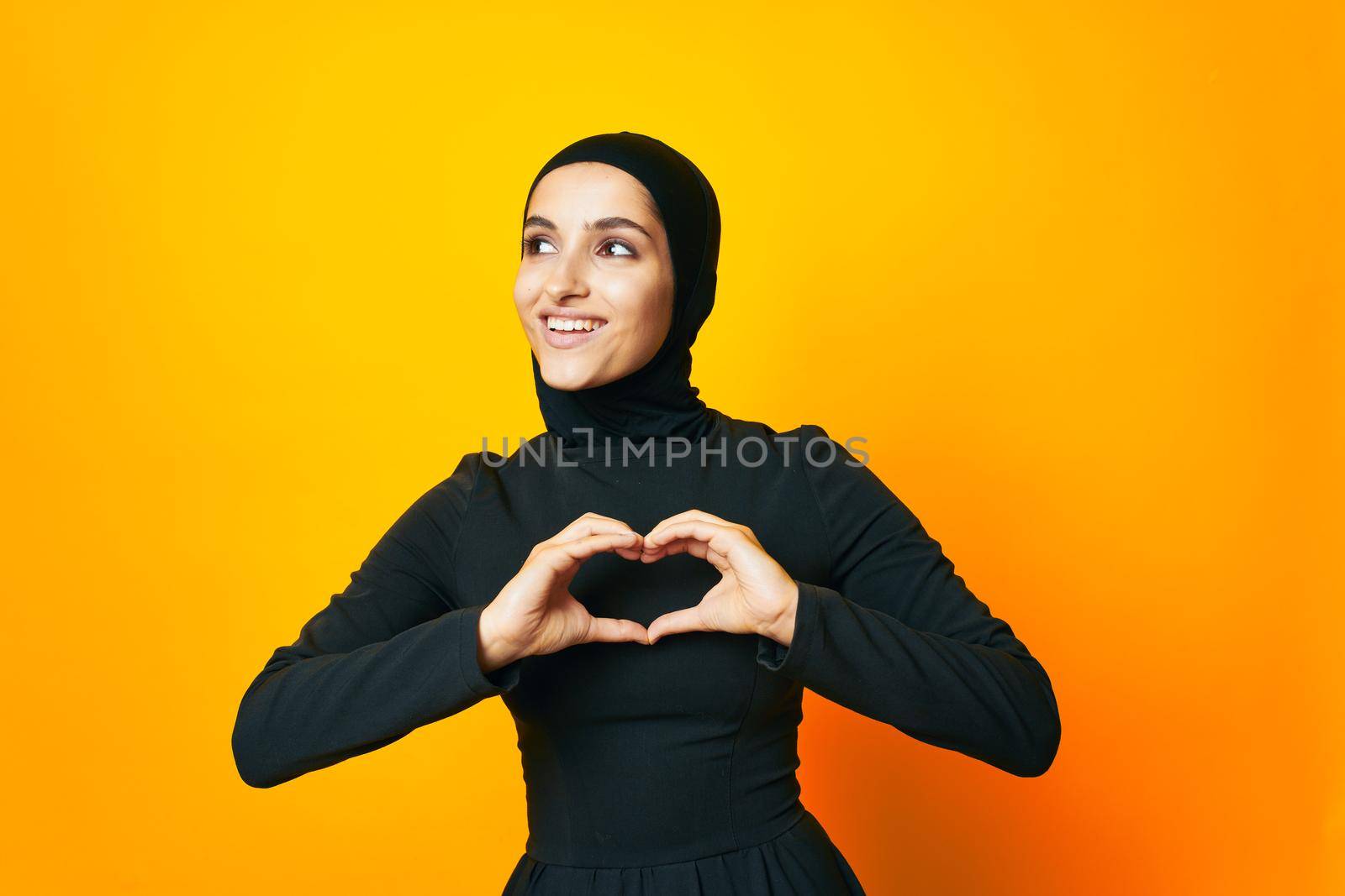 pretty woman in black hijab posing fashion hand gesture isolated background. High quality photo