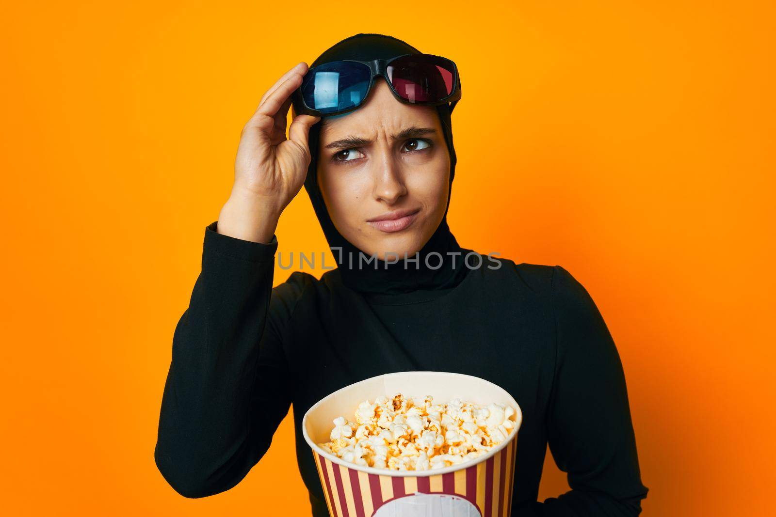 pretty woman in black hijab popcorn 3D glasses cinema ethnicity model. High quality photo