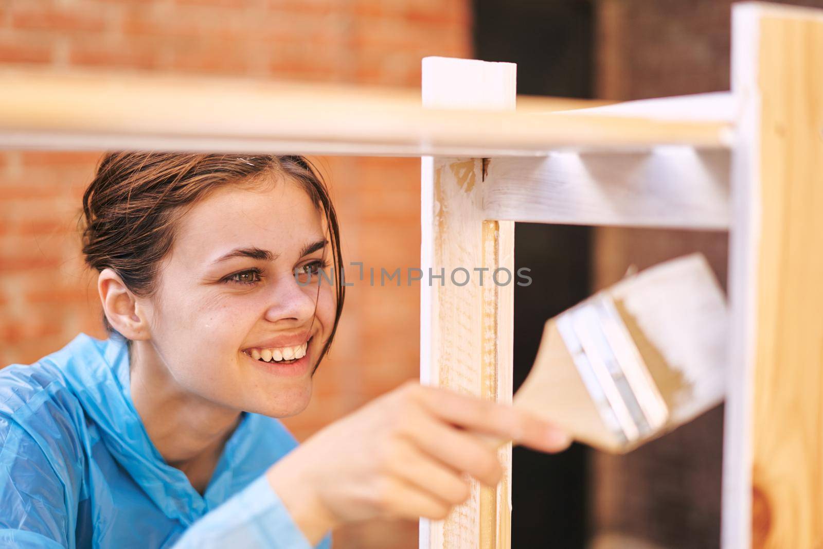 cheerful woman house painter in protective suit repairing home. High quality photo