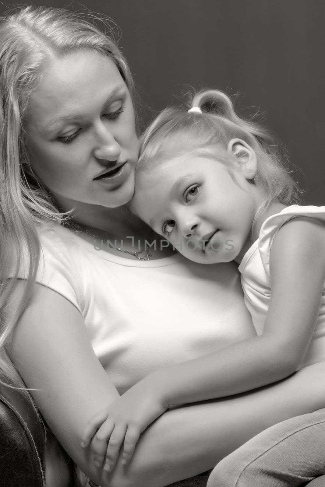 Young mother and little daughter gently embrace. The concept of Happy Childhood, Family Happiness, Raising a Child.