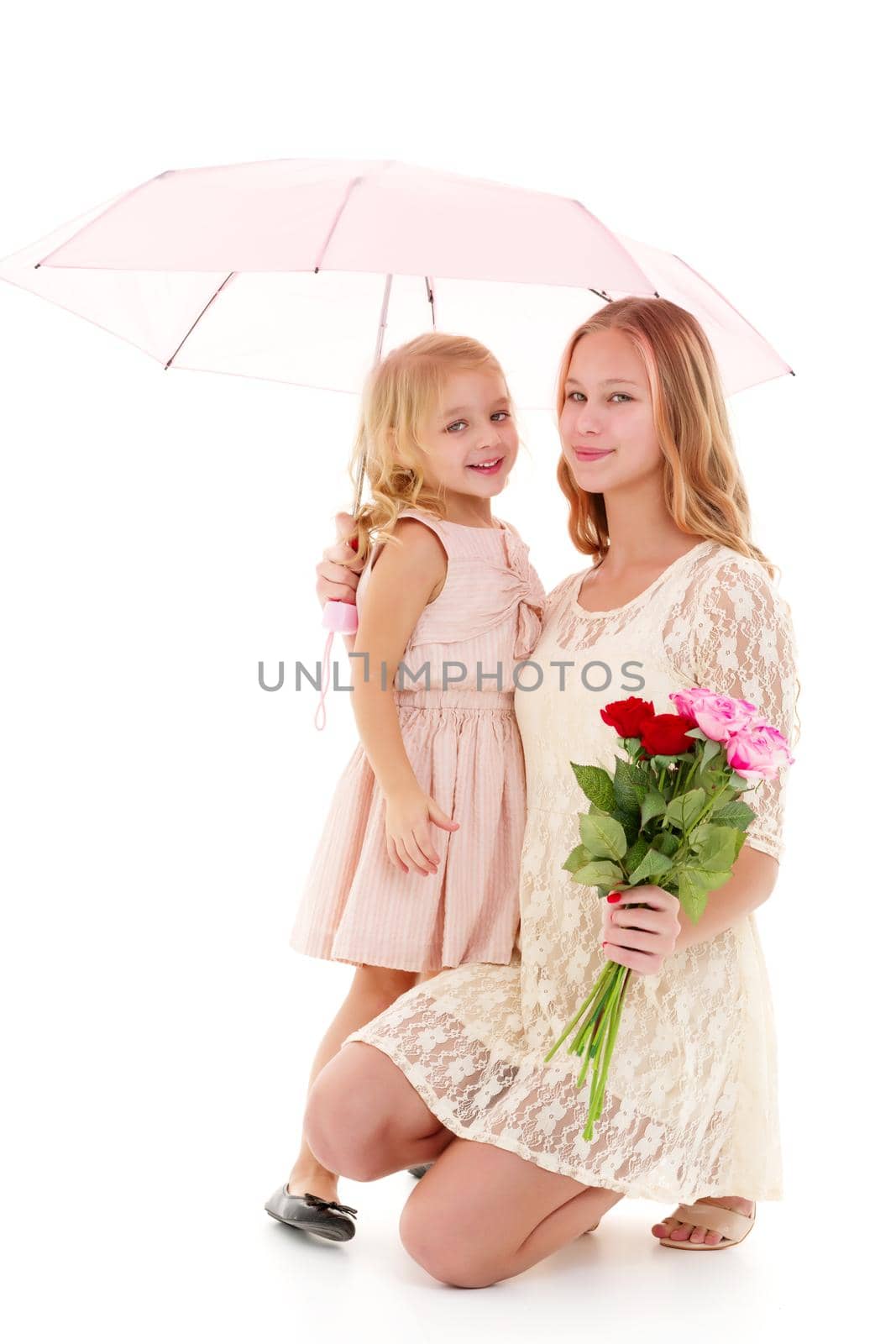 Lovely little girls hid under the umbrella. The concept of a happy childhood, family vacation. Isolated on white background.