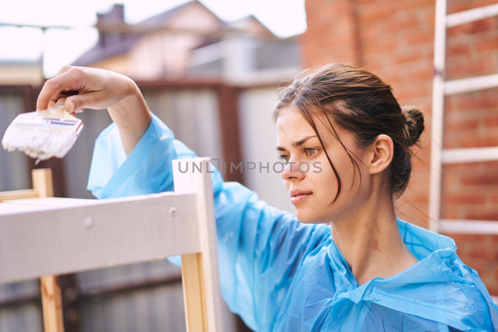 cheerful woman house painter in protective suit repairing home. High quality photo
