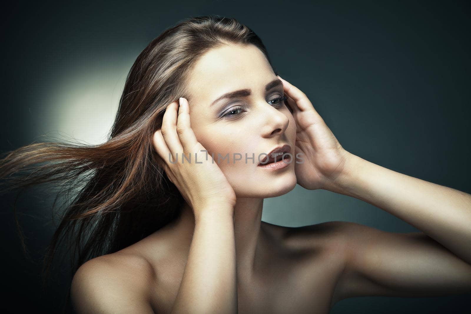 Sensual young woman with beautiful long brown hairs, posing. Studio shot