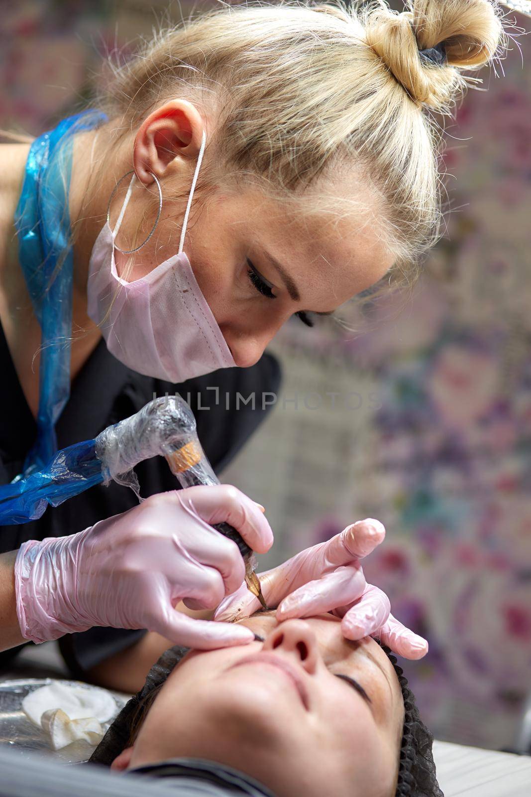 permanent makeup, eyebrow tattooing. The master makes permanent makeup using machine tattoos