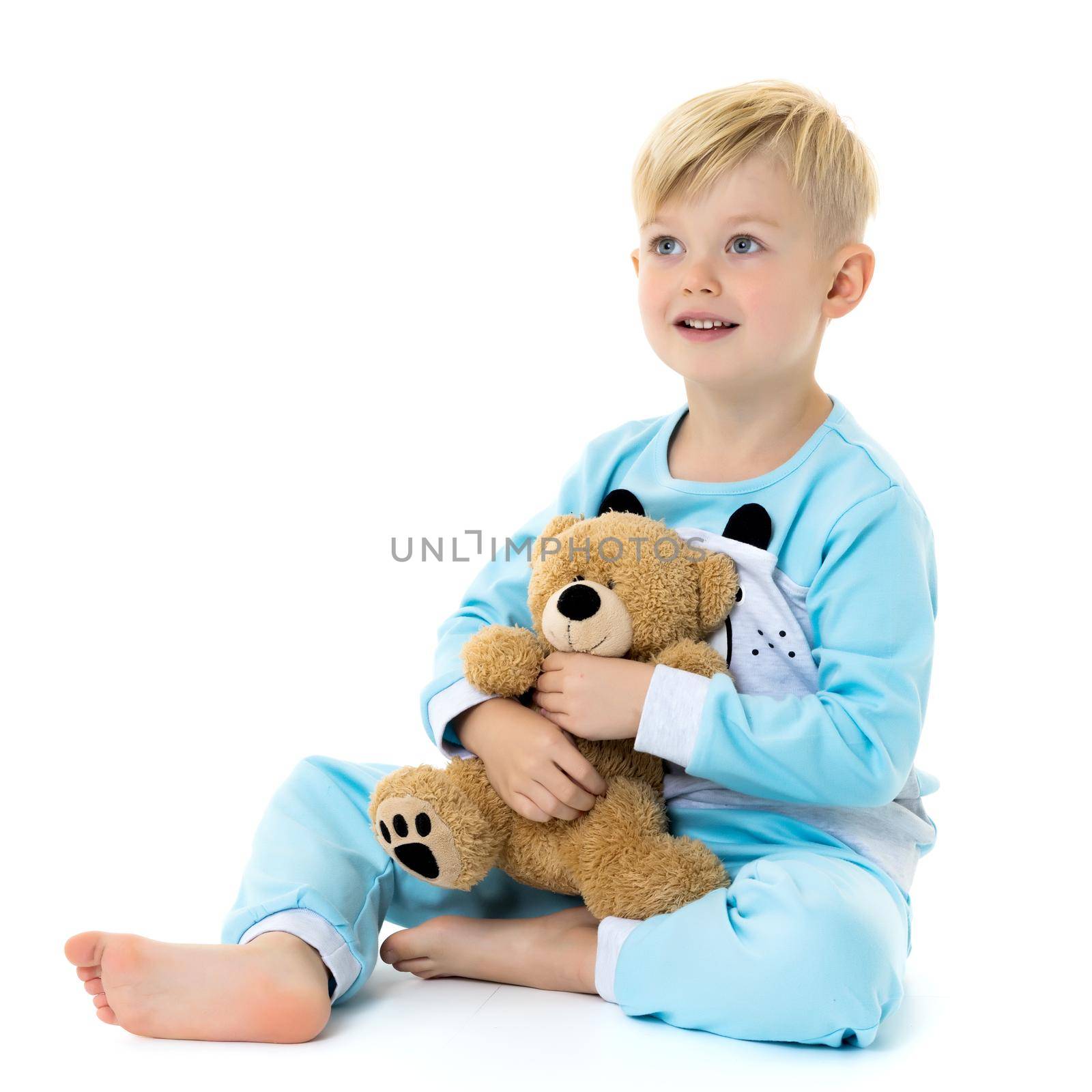 Cute little boy in pajamas with a teddy bear. The concept of family happiness. Isolated on white background.