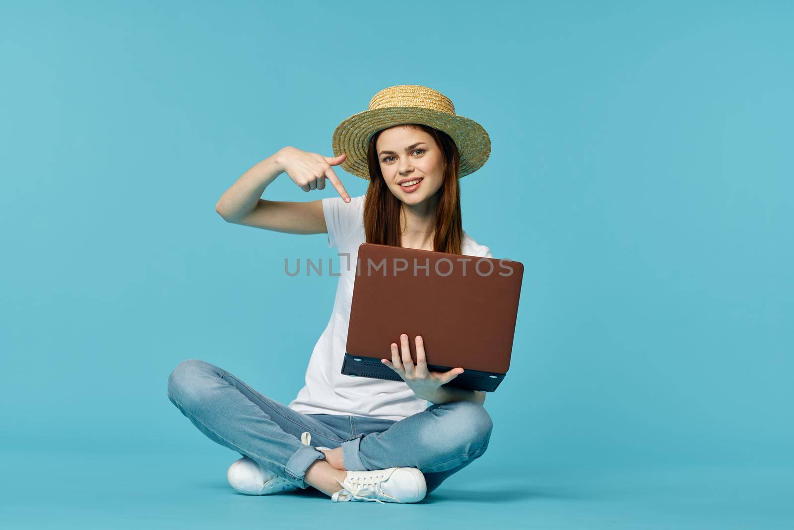 woman with laptop learning internet online education blue background. High quality photo
