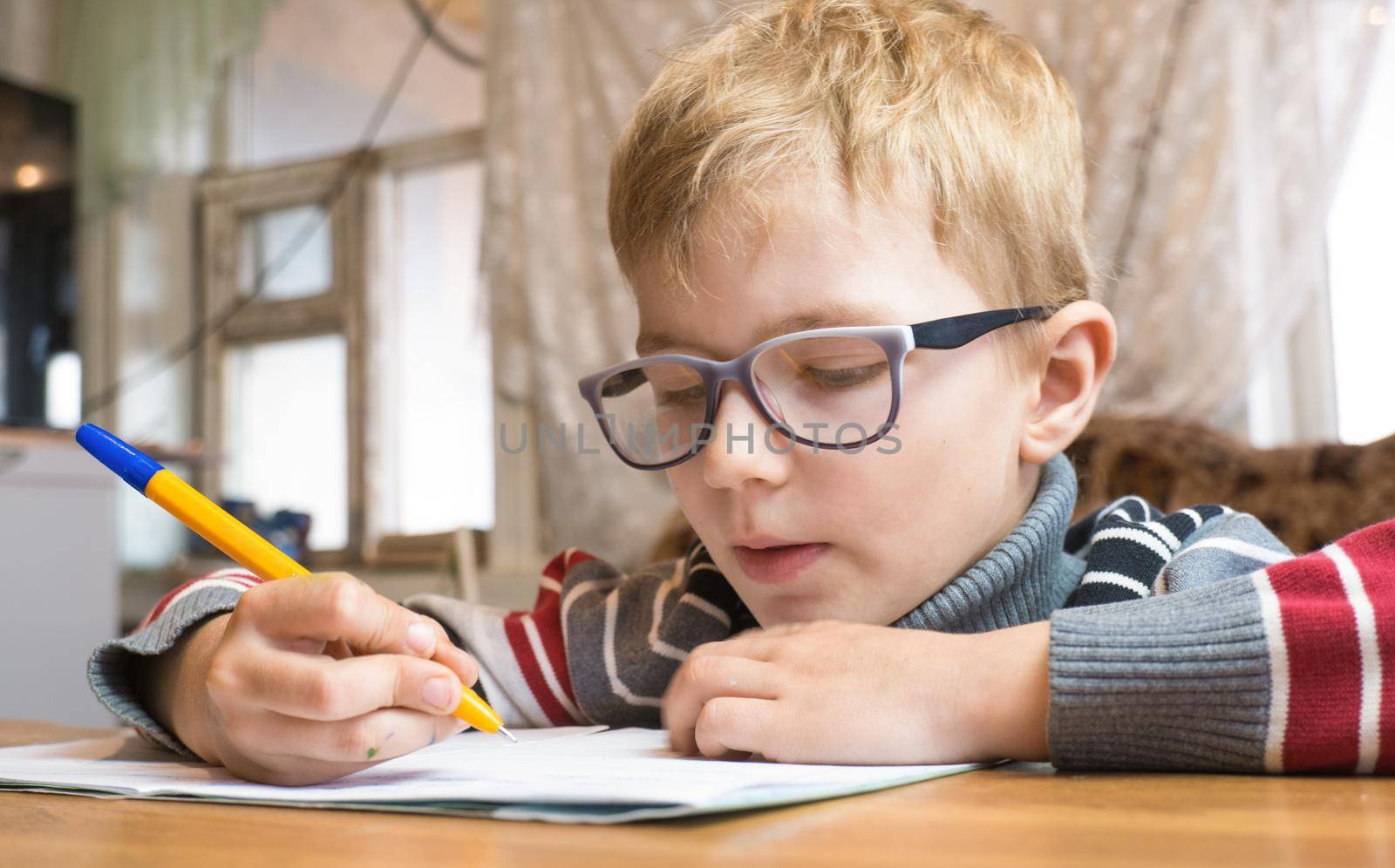 Focused first grader learning to write and doing homework.