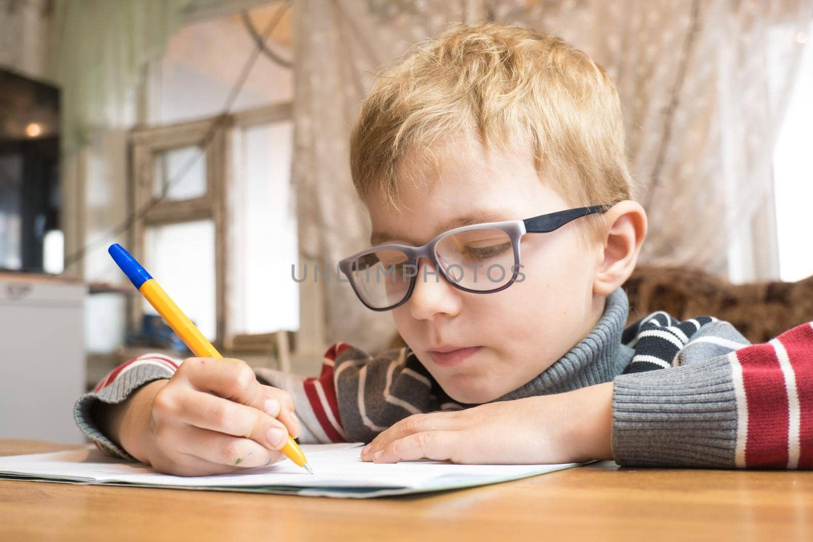 Focused first grader learning to write and doing homework.