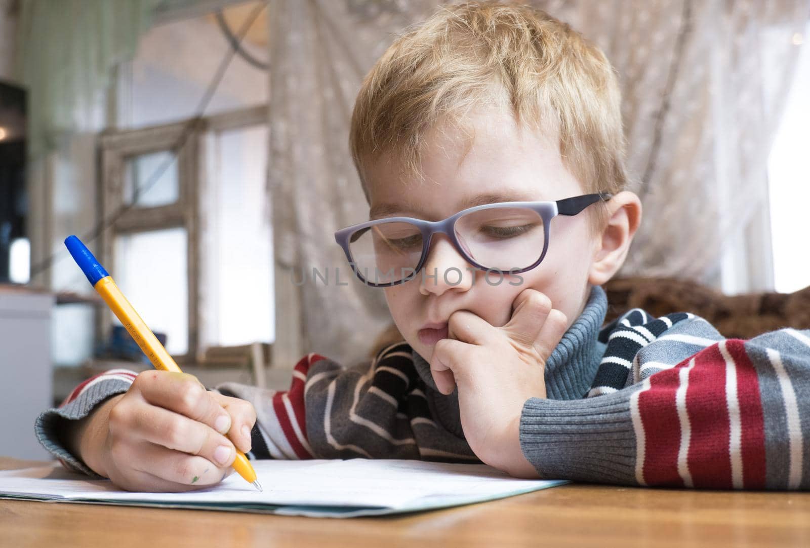 Focused first grader learning to write and doing homework.