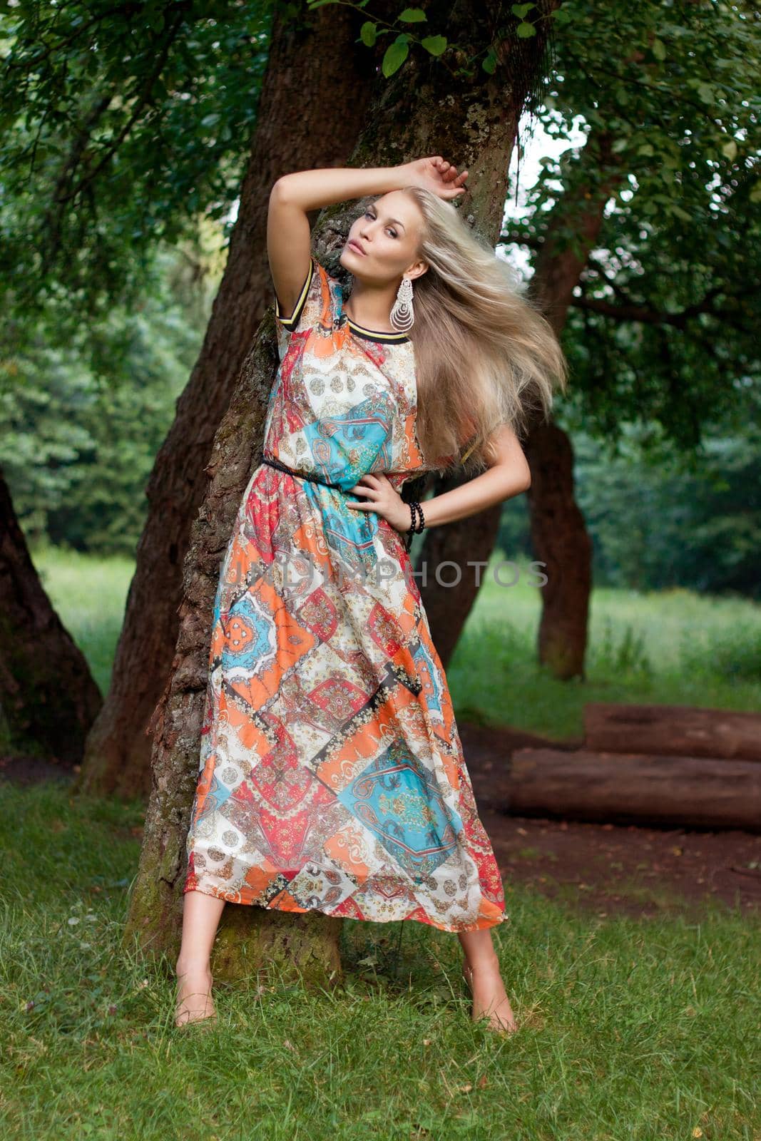 Sexy woman outdoor with nice colorful dress in garden