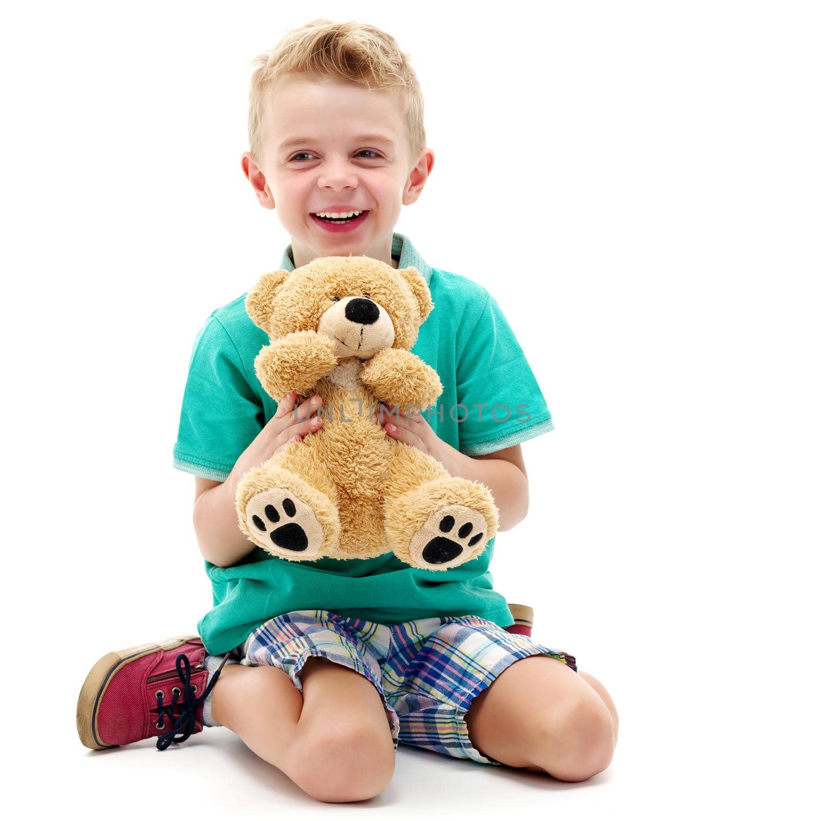 A little boy is playing with a teddy bear. The concept of a happy childhood, games, the development of a child in the family.