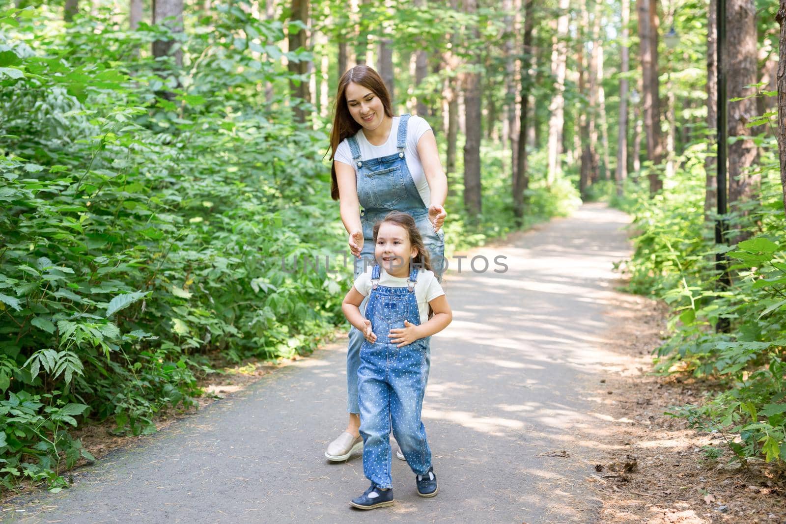 Family, parenthood and nature concept - Mother with daughter having fun in the green park by Satura86