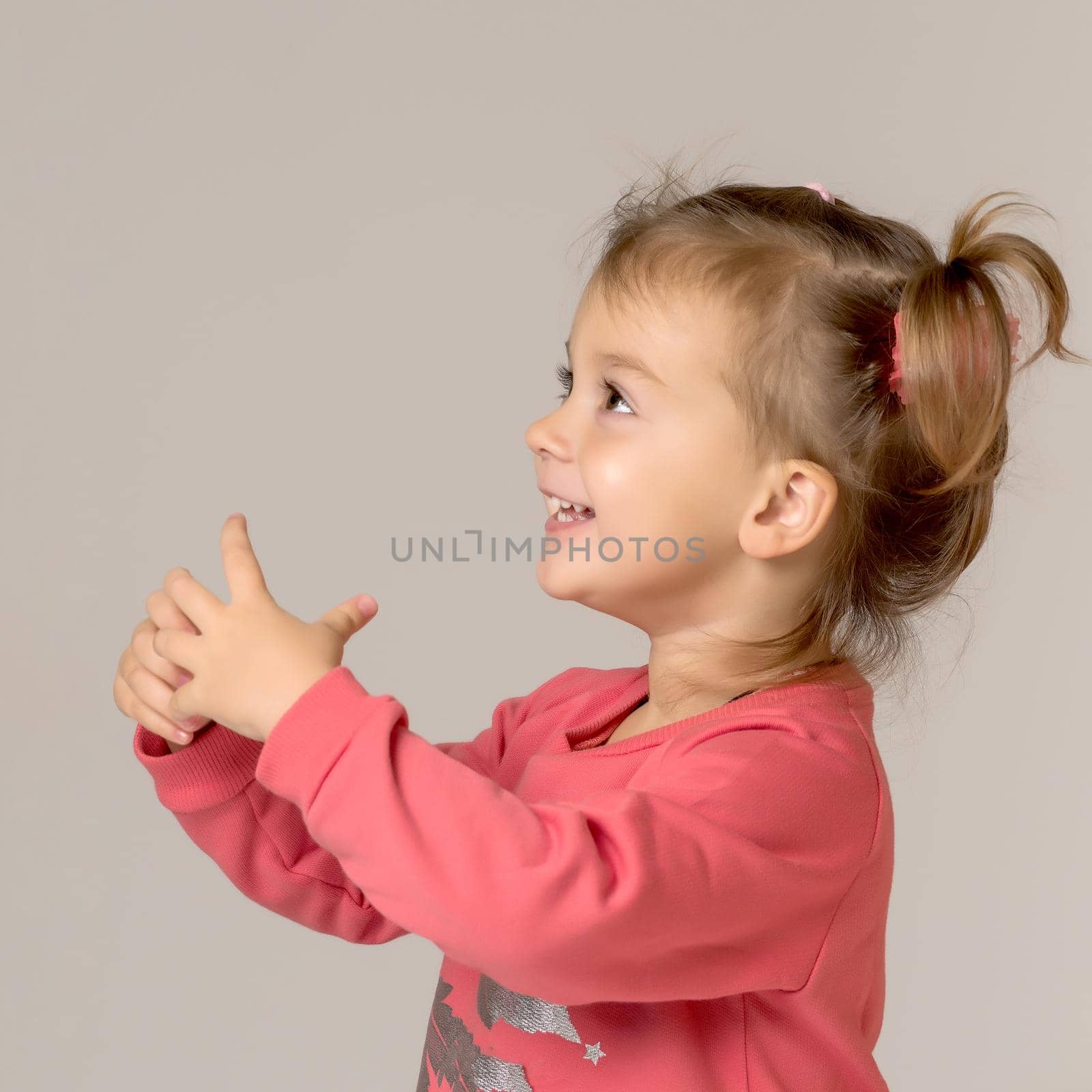 A happy little girl is waving her hand. by kolesnikov_studio