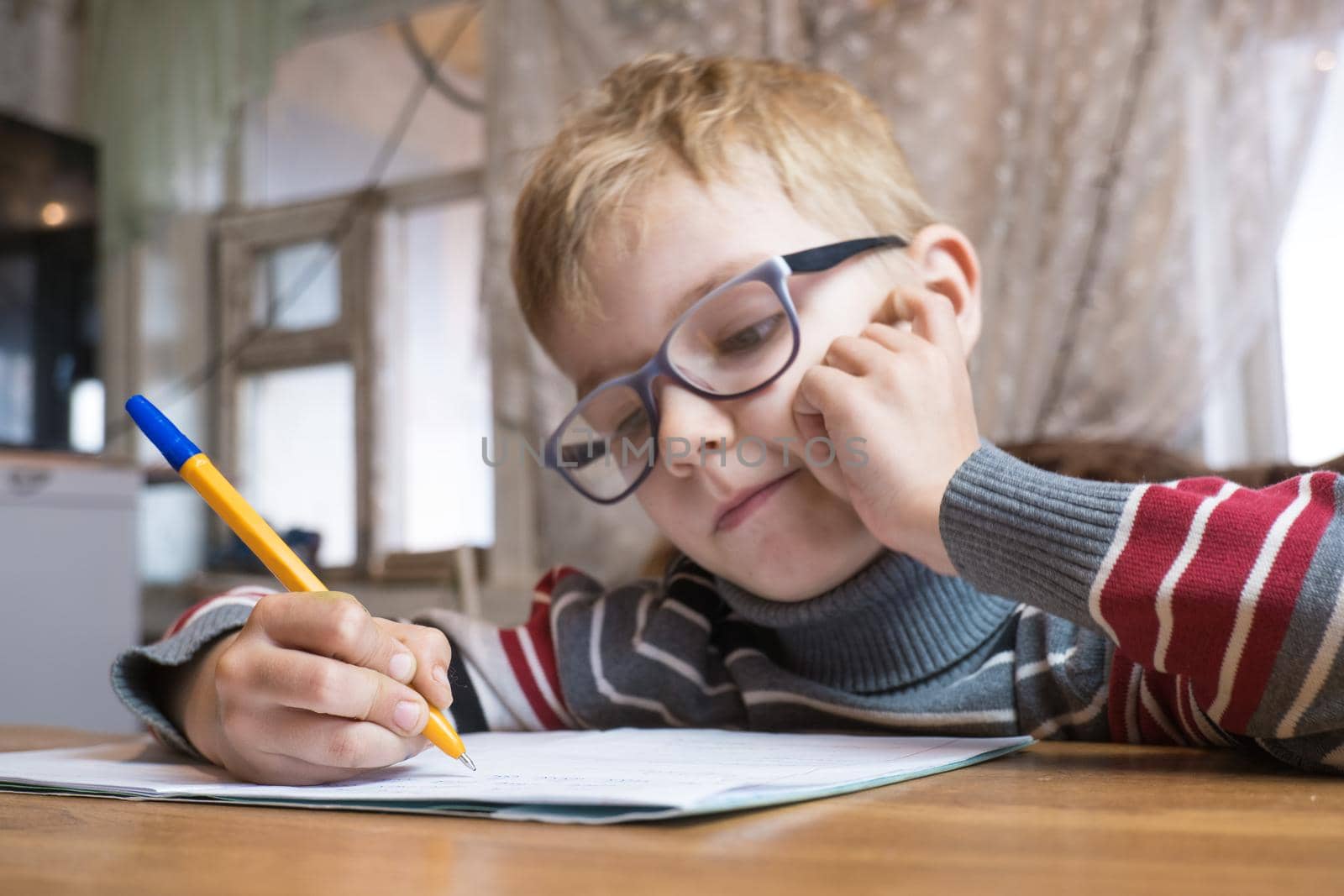 Focused first grader learning to write and doing homework.