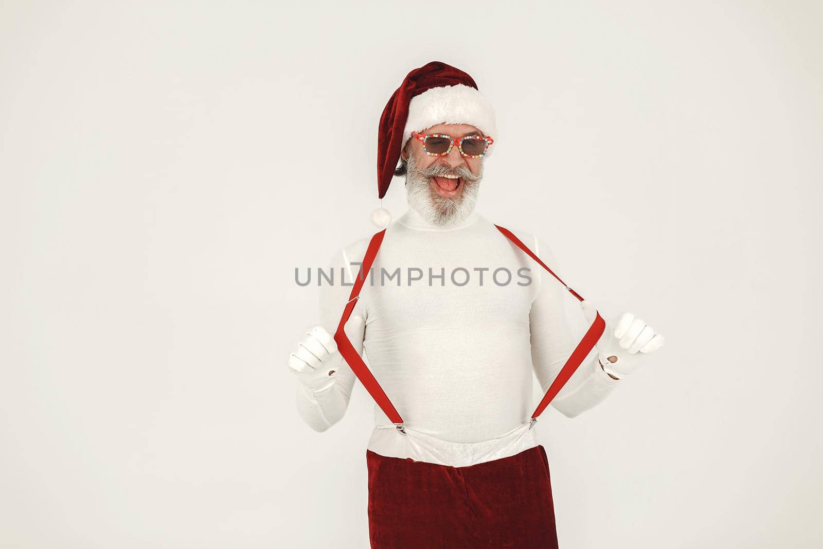 Trendy grey-haired santa. Man wear knitted clothes. Grandfather in a santa's hat.