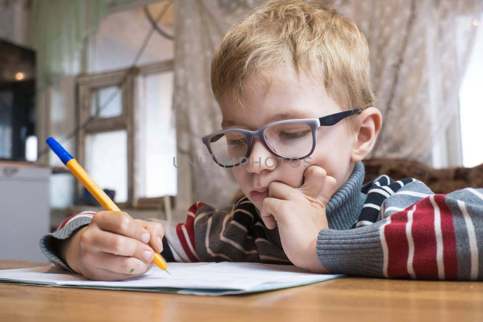 Focused first grader learning to write and doing homework.