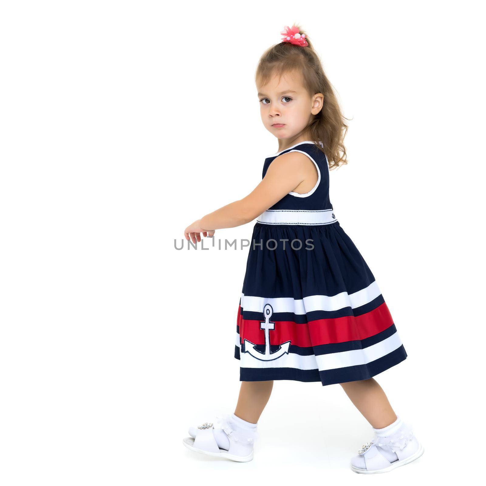 A cute little girl is walking fast. Isolated on white background.