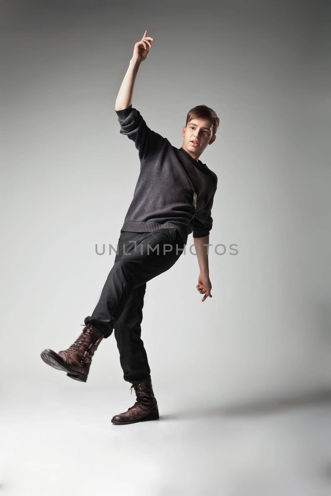 Young fashion male jumping on grey background by Julenochek