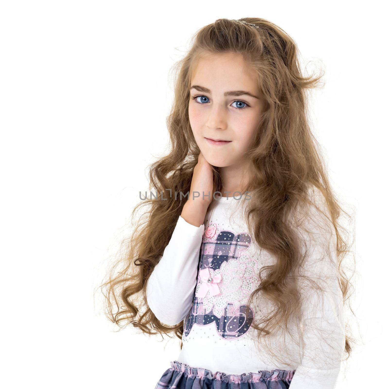 A charming little girl folded her hands around her face. The concept of beauty and fashion, children's emotions. Isolated on white background.