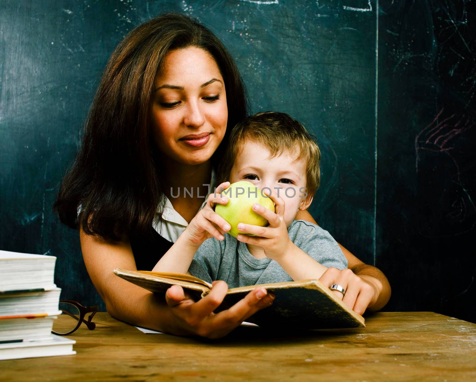 little cute boy in glasses with young real teacher, classroom studying, lifestyle people concept closeup