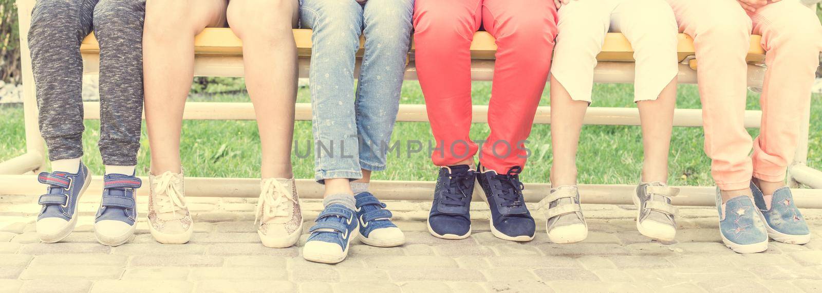 View of children legs ,sitting on the bench