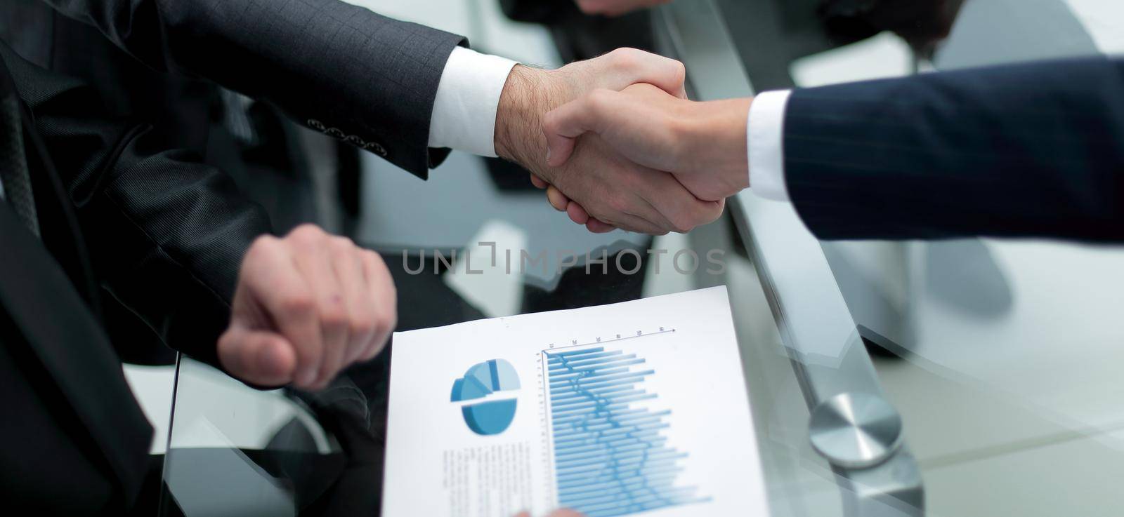 close up. investor and businessman shaking hands by asdf