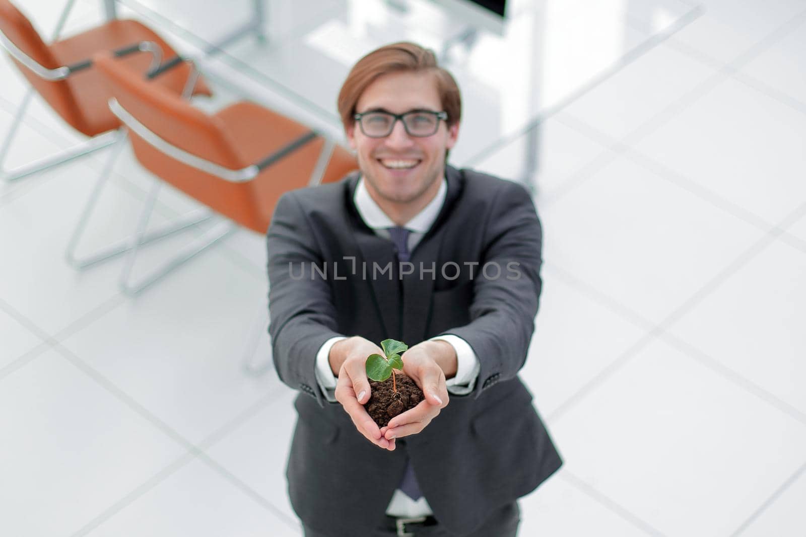 top view.young businessman showing green sprout