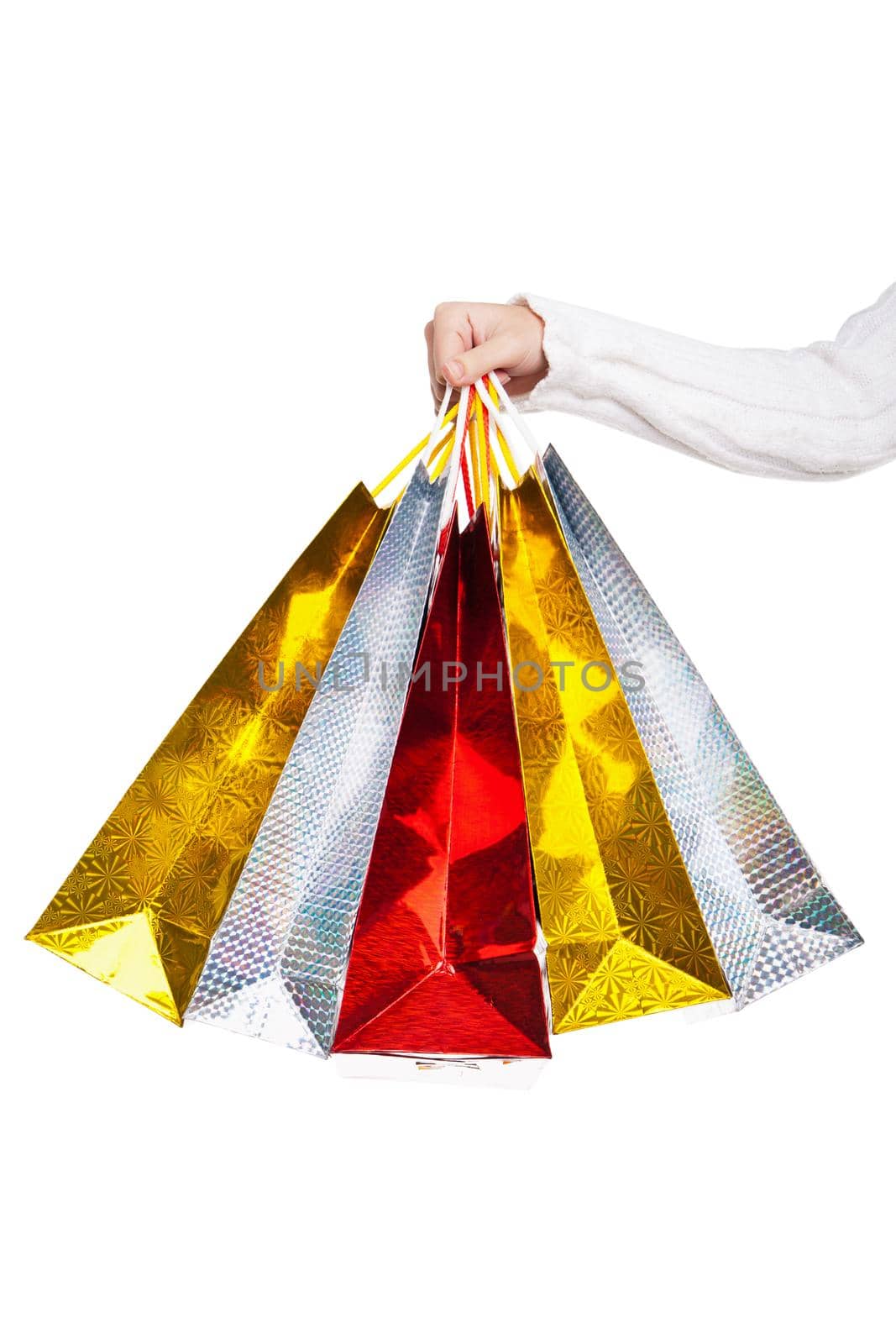Womans hand holding colorful shopping bags isolated on white background