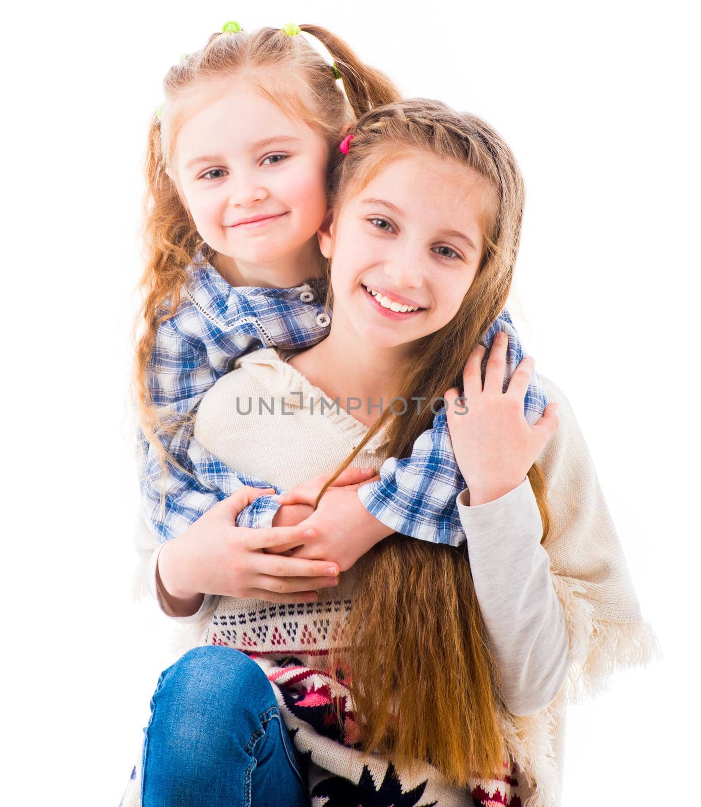 Portrait of two joyful beautiful sisters embracing warmly isolated on white background