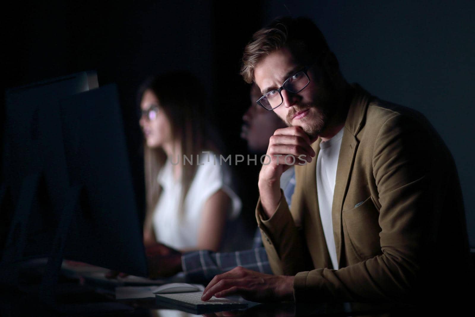 close up.serious businessman in the workplace .photo on black background