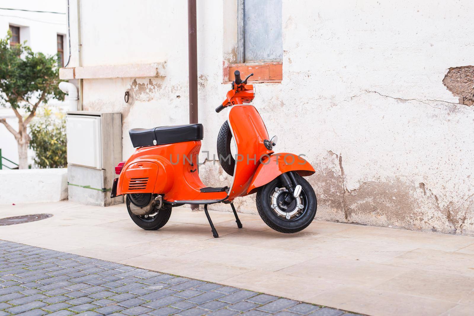 Barcelona, Spain - January 13 , 2018: Orange Scooter Vespa parked on old street in Barcelona, Spain.