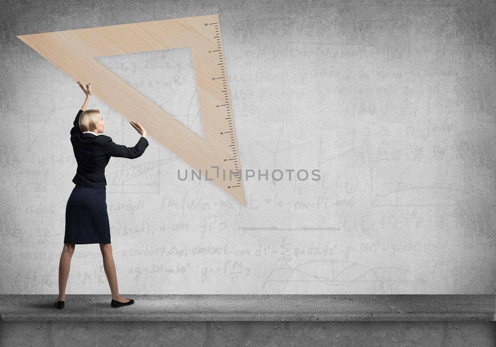 Woman holding big ruler on wall background. Testing and examination concept. Businesswoman measuring something with ruler. Human resources recruitment. Creative motivation, coaching and mentoring.