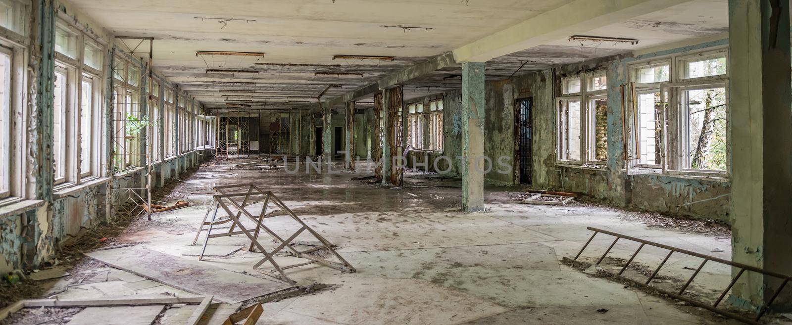 ruined abandoned school hall with debris and remains in Pripyat