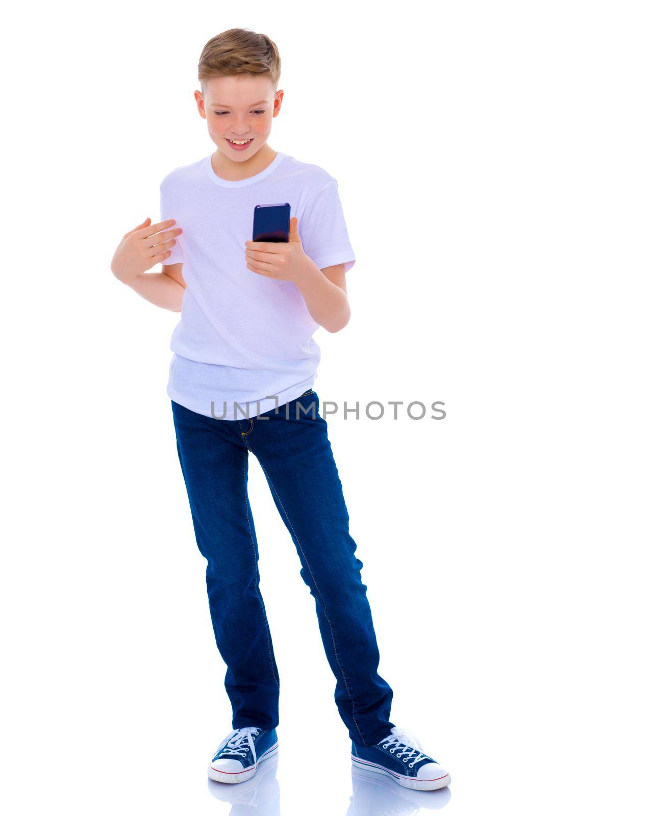 A small boy of school age uses a mobile phone. The concept of digital technology, communication between people. Isolated on white background.