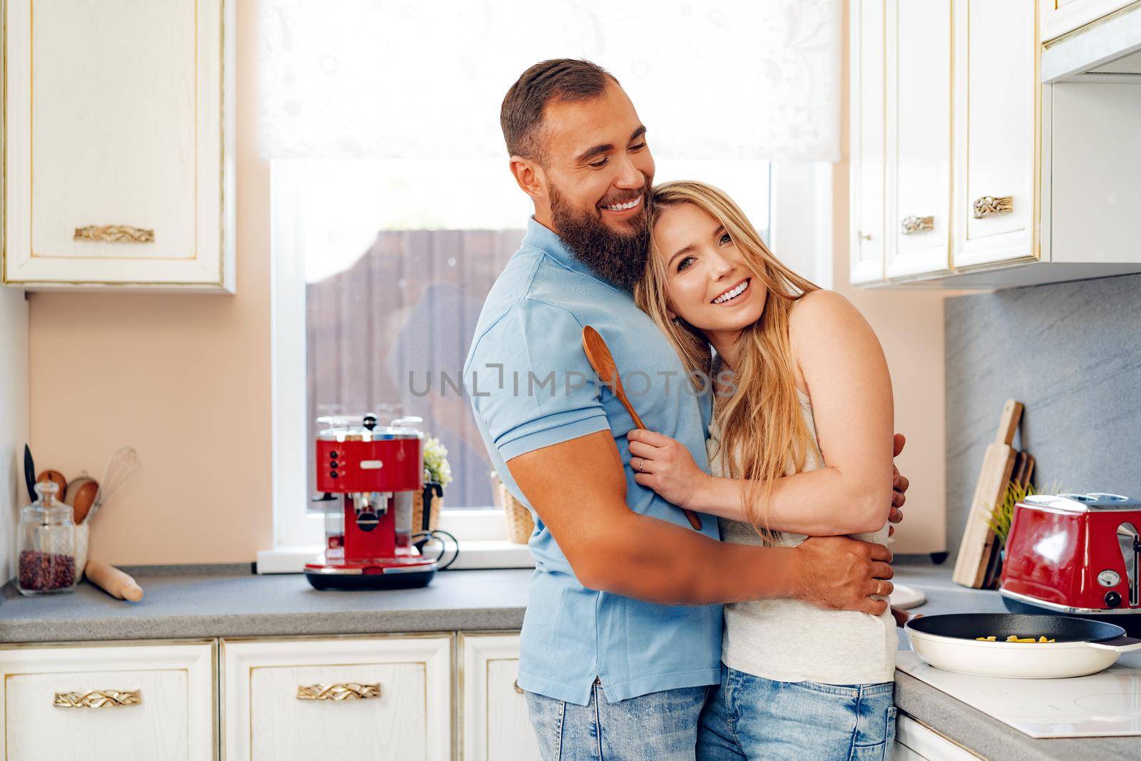 Young loving couple cooking together in kitchen at home