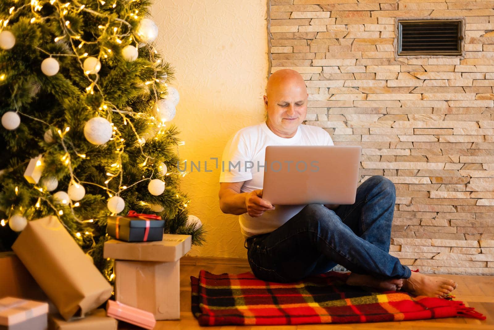 christmas, holidays and people concept - happy smiling senior elderly man sitting with laptop online at christmas at home