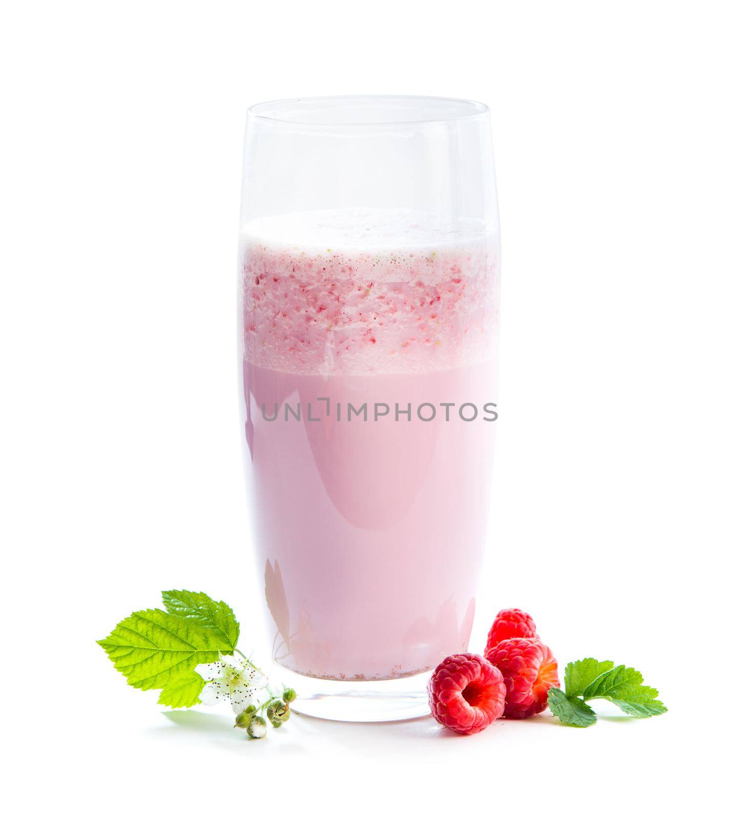 glass of milkshake, berries and green twig of raspberry isolated on white background