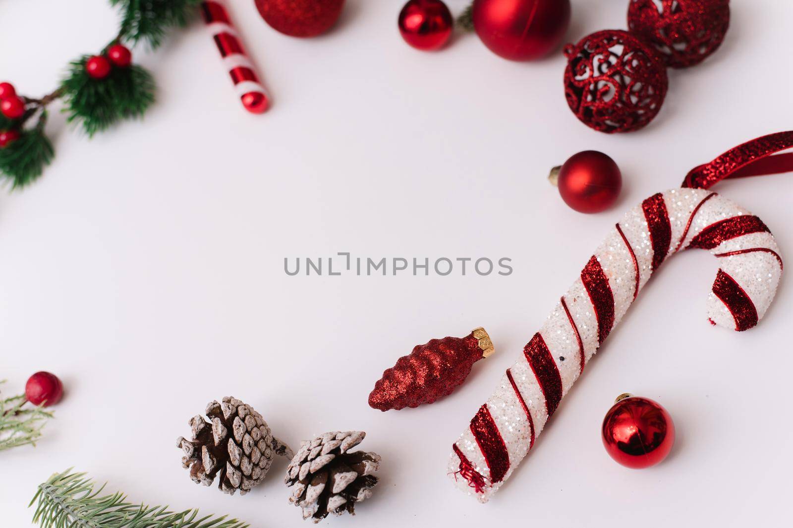 Christmas composition with fir branches, red decorations on a white background with copy space for your text. Christmas, winter, new year concept. Flat lay, top view, copy space.