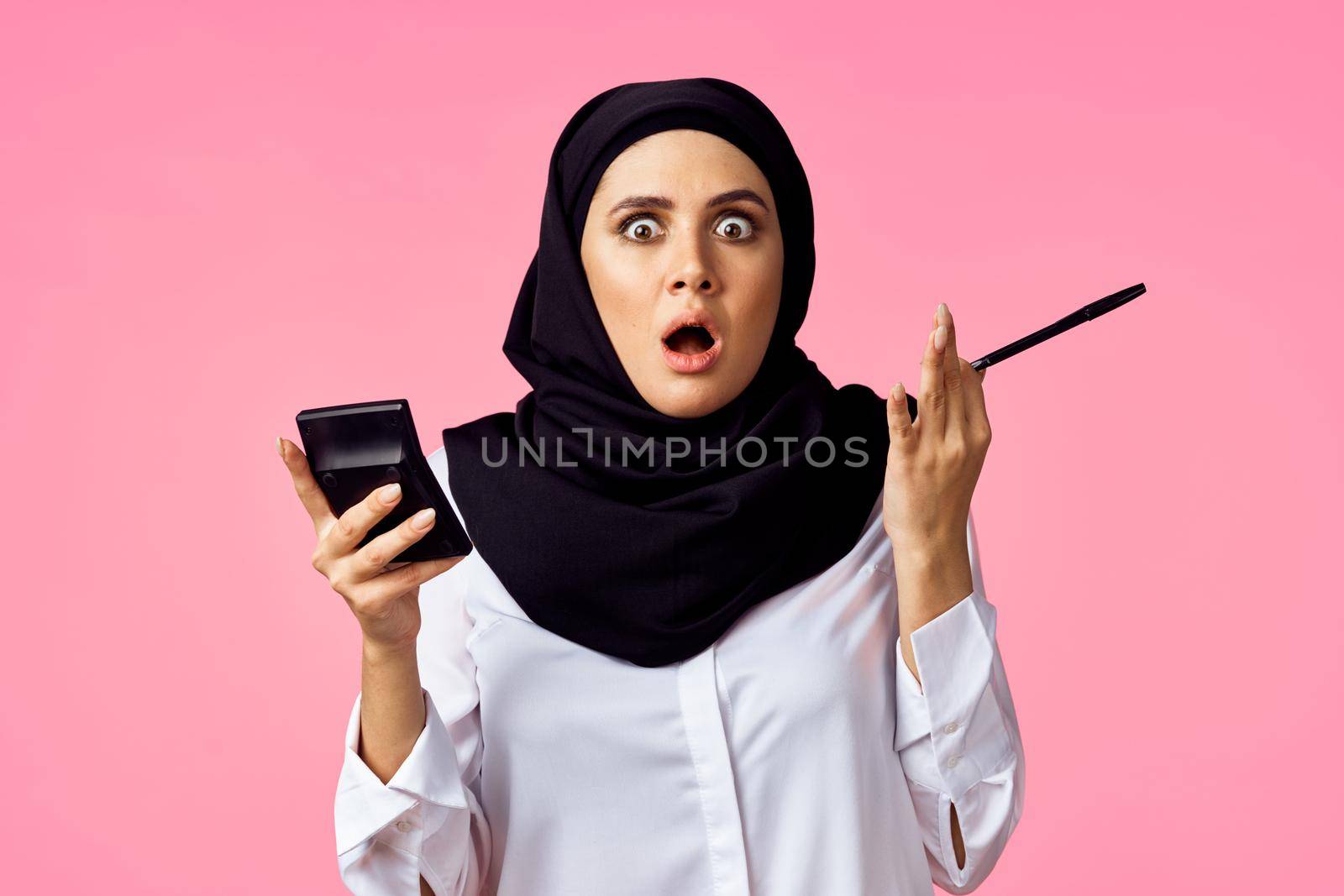 muslim woman with calculator and finance money pink background. High quality photo