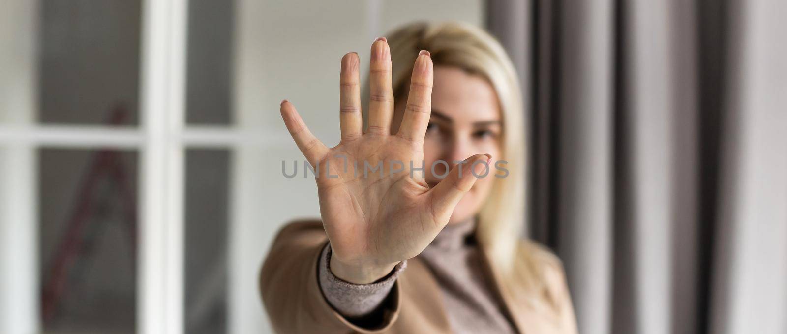 Portrait of young woman making stop sign with her hand