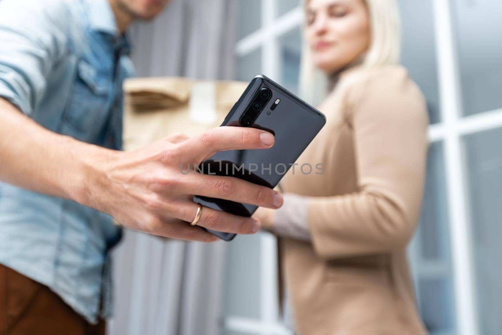 Happy deliverer carrying packages while making home delivery to his customer