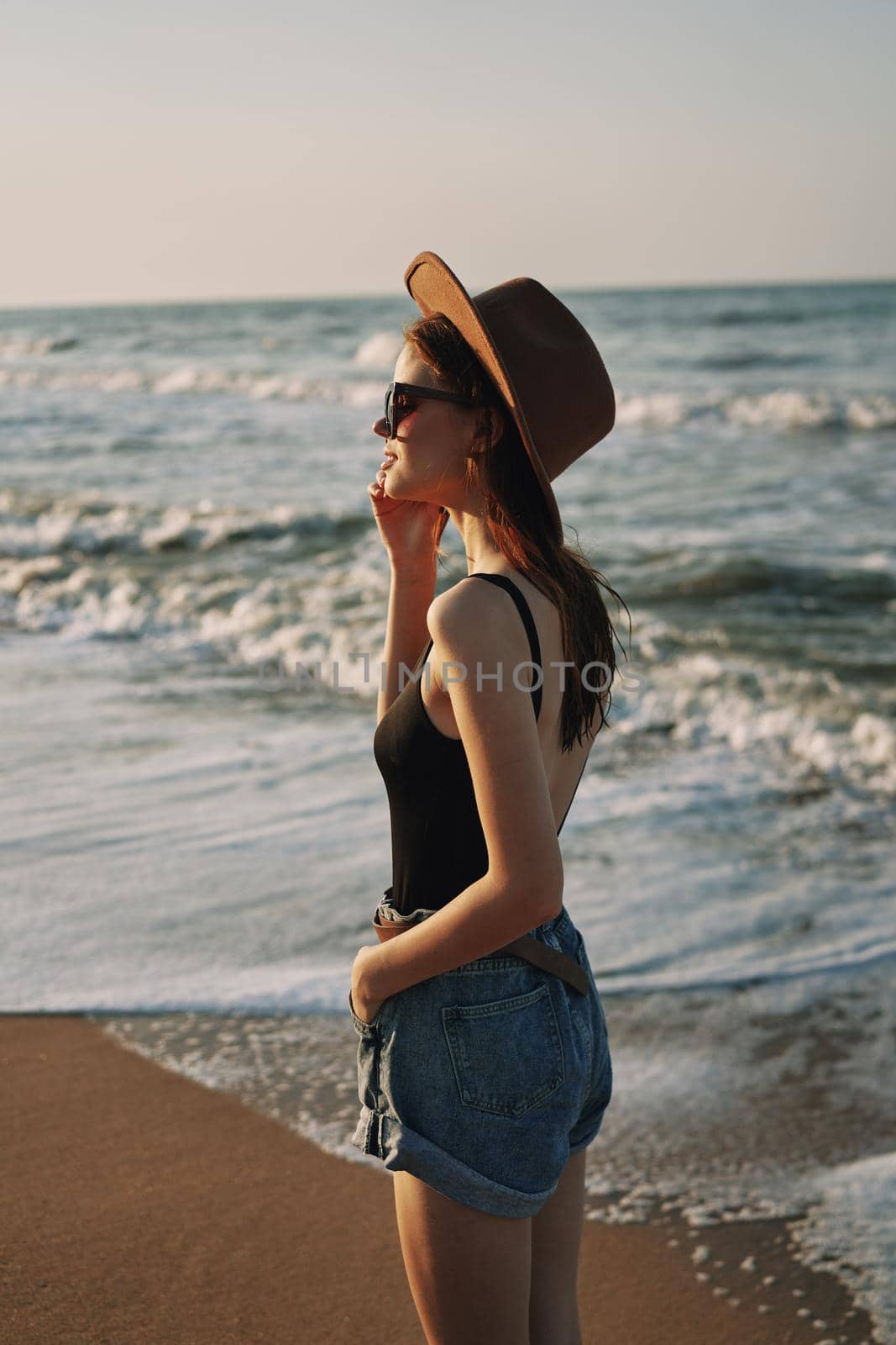 woman walking on the beach hat travel vacation sun. High quality photo