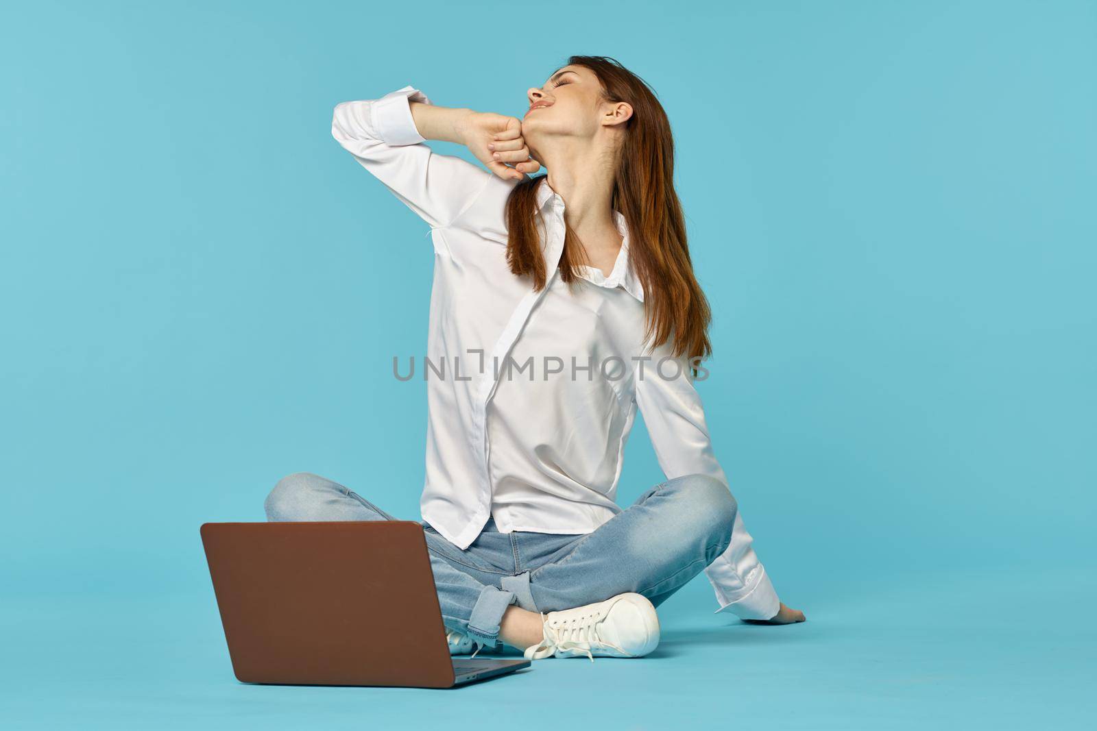 woman with laptop learning internet online education blue background. High quality photo