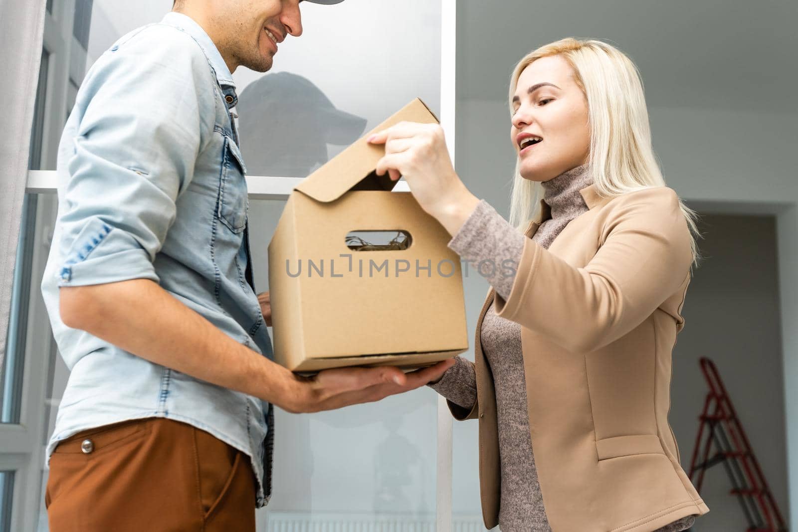 View of a Delivery man handing over a parcel to customer by Andelov13